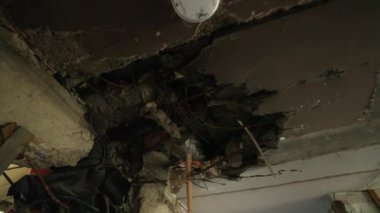 Yıkım, savaş bölgesinde korunmasız altyapı, iç hasar kanıtları oluşturma. Açığa çıkan kablolar, Mariupol 'ün apartmanının tavanındaki beton patlaması. Yavaş çekim.