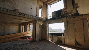 Yanmış duvarlar, çökmüş tavanlar, açığa çıkmış çerçeveler. Mariupol 'deki harap apartmanın iç manzarası, savaş hasarı görülüyor. Kırık pencerelerden görünen şehir manzarası.