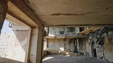 Çatışma sonrası çekilen görüntüler, yerleşim alanındaki yıkım. Mariupol 'deki çökmüş tavanları, yanmış duvarları, açık kirişleri, yerde molozları olan savaştan zarar görmüş bir apartmanın içinde..