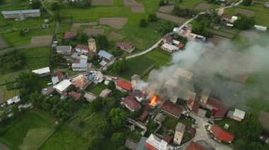 Svan Kulesi 'nin Mestia, Svaneti Dağları Vadisi, Georgia' daki hava manzarası yanıyor. Tarihi taş kule yanıyor, yoğun duman. Kırsal köy manzarası acil durum müdahalesi. Miras faciası. İHA