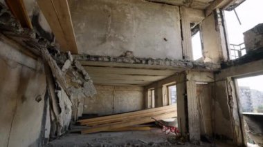 Terk edilmiş kalıntılar yerleşim alanındaki çatışma etkilerini yansıtıyor. Yıkımı ve kayıpları ortaya çıkarıyor. Mariupol 'deki savaştan zarar görmüş apartman dairesinin tavanı çökmüş, kirişler ortaya çıkmış..