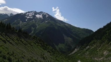 Karla kaplı tepeleri olan Svaneti dağlarının hava manzarası. Zengin yeşil vadiler, huzurlu manzaralar. Güzel doğa sahnesi. Görkemli çıkıntılar ve açık gökyüzü. Seyahat için mükemmel, ekolojik macera içeriği. İHA
