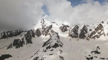 Karla kaplı tepeleri ve bulutlu gökyüzü olan Svaneti dağlarının hava manzarası. Georgia 'da kış manzarası. Seyahat, turizm, doğa, macera meraklıları için. Görkemli dağ sıraları nefes kesici manzara.