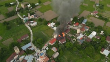 Svan kulesi Mestia, Svaneti dağlarında yanıyor. Yanan binalar, yanan alevler, şehrin havadan görünüşü. Acil durum ekipleri olay yerinde. Dağlık bölgedeki kırsal köy. Kültür Mirası Bölgesi.