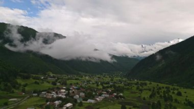 Svaneti dağlarındaki Mazeri köyünün hava manzarası. Yeşil vadi, yoğun bulutlar, pitoresk manzara. Dağlarda yaz günü. Turizm tanıtımları, doğa belgeselleri için ideal. İHA atışı
