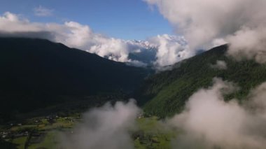 Svaneti dağlarındaki Mazeri köyünün hava manzarası. Sabah sisi, arka planda karla kaplı tepeler. Kırsal alan, yumuşak erken ışık altında. İHA atışı