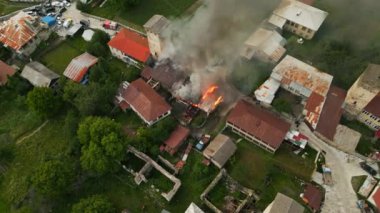 İtfaiyeciler Mestia 'daki Svan Kulesi' nde yangın söndürüyorlar. İtfaiye aracı duman dalgaları sunuyor. Svan kulesi yanıyor. Geleneksel evleri olan bir yerleşim yeri. Tarihi köyde havadan ateş manzarası. İHA