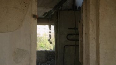 Savaş tahribatı, yıkım binaları etkiler. Mariupol 'de savaştan zarar görmüş bir apartman dairesi yıkım, paslı borular, ateş altında harap olmuş beton ve bombardıman darbeleri gösteriyor. Yavaşla