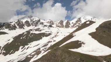 Sırt çantalı yalnız gezgin kollarını açıyor, Svaneti dağlarının manzarasından hoşlanıyor. Yalnız gezgin doğada özgürlüğü tecrübe eder. Karlı zirvelerde maceraperest, bulutlu gökyüzünde. Yürüyüş, keşfe çıkmak, dışarı çıkmaktan keyif almak..