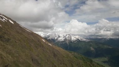 Kar tepeleri, vadileri olan Svaneti dağlarının hava manzarası. Bulutlar havada süzülüyor, dramatik bir manzara yaratıyor. Doğa, macera turizmi, açık hava keşfi. Yürüyüşü, yürüyüş dağcılığı meşhurdur..
