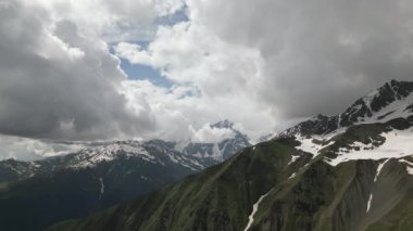 Svaneti 'deki Kafkas dağlarının havadan görünüşü. Kar tepeleri, yeşil vadiler, bulutlu gökyüzü. Manzarası, doğa, macera, yürüyüş, ekolojik seyahat. Uzak, el değmemiş bir çevre. İnsansız hava aracı ile popüler.