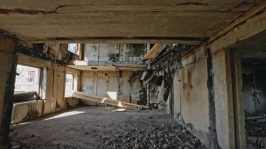 Görünür iç yıkım, ışığa maruz kalan kirişler, enkaz yığınları. Savaştan zarar görmüş apartman daireleri çökmüş tavanlar, yanmış duvarlar..