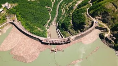 Gürcistan 'daki İnguri hidroelektrik barajının havadan görünüşü. Kafkasya 'da büyük bir baraj. Su deposu olan hidroelektrik santrali. Yeşil tepeler binanın etrafını sarmış. Mühendislik harikası geliştirme, yenilenebilir enerji. İHA