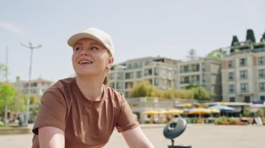 Kadın bisikletçi güneşli kentsel alanları keşfediyor, etkinlik sırasında gülümsüyor. Büyükada Adası 'nda bisiklet süren, şehir manzarasını seven bir kadın. İstanbul arka planında eğlence gezisi, açık hava sporu.