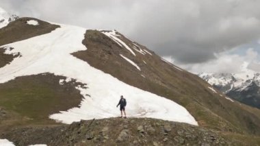 Solo sırt çantalı hava aracı özgürlüğün tadını çıkarıyor. Gezgin Svaneti dağlarını keşfeder, kollarını açar, manzarayı takdir eder. Karlı tepelerde tek başına yürüyüş yapmak. Georgia 'daki macera. Doğa, açık hava, seyahat yalnızlığı..
