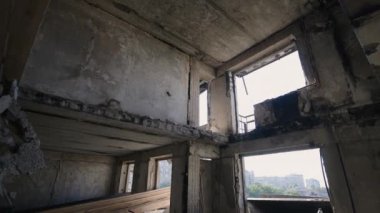 Çıplak beton duvarlar ve yakın zamandaki çatışmaya dair ipuçları. Mariupol 'de savaştan zarar görmüş bir dairenin iç manzarası, çökmüş tavanlar, açık kirişler ve kırılmış pencereler bir yıkım hikayesi anlatıyor..