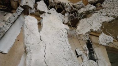 Hasarlı beton takviyesi ve çöken tavanlar. Videoda Mariupol 'de savaşın yıktığı bir apartman dairesi var. Çatışma sonrası yıkıcı yapı, enkaz manzarası.