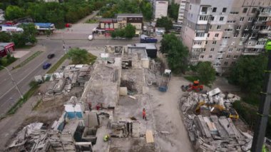 İşçiler enkazı temizler, çatıdan yıkım sürecini denetlerler. Crane savaştan zarar görmüş beton apartmanı söküyor. Kentsel yenileme, çatışma sonrası yeniden yapılanma gerçek zamanlı olarak ele geçirildi. Zaman Uygulaması