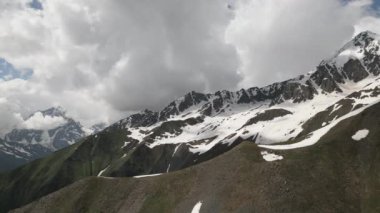 Svaneti 'deki Kafkas dağlarının hava manzarası. Yeşil vadiler, bulutlu gökyüzünün altındaki kayalık tepeler. Seyahat, doğa ve macera teması için ideal. Göz kamaştırıcı bir dağ sırası. İHA atışı