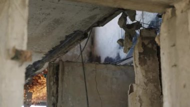 Öğütücü takviyeyi keserken kıvılcımlar uçuşuyor. İşçiler Mariupol 'ün dairesindeki hasarlı tavanı söküyorlar. Savaş sonrası, binanın iç kısımları mermi ve ateş darbesi gösteriyor. Yavaş çekim.