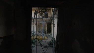 Kasklar, güvenlik ekipmanları enkazı kaldırmak, konut yenileme alanı inşa etmek. İnşaat işçileri hasarlı tavanları söküyor. Yanmış matkaplı duvarlar, savaştan zarar görmüş apartman daireleri yeniden inşa ediliyor..