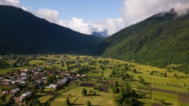 Hava manzaralı Mazeri köyü dağları Svaneti. Yeşil vadiler, dağınık evler sisli tepeler. Huzurlu köy manzarası. Şafak vakti güzel bir manzara. İHA atışı