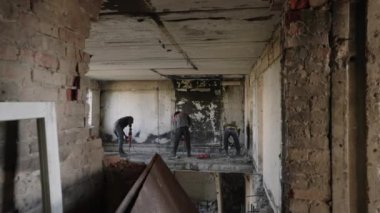 Şehir yenilenmesi için enkaz dolu binada ekip takviyesini kesti. İnşaat işçileri savaştan zarar görmüş apartmanı yıkıyor, duvarı matkapla yıkıyor. Konut alanındaki yeniden yapılanmaya odaklan.
