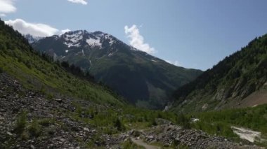 Kar tepeleri, yemyeşil vadileri ve kayalık arazisi olan Svaneti dağlarının hava manzarası. Gökyüzü açık, yaz günü. Doğa yürüyüşü, doğa keşfi ve macera yolculuğu için manzara. İHA atışı