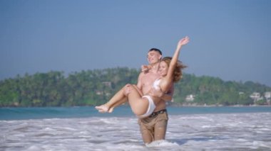 Denizde dönen bir kadın için zinde bir atletik. Gülümseyen bir çift romantik balayında okyanus suyunda öpüşüyor ve eğleniyor. Erkek arkadaş ve kız arkadaş tropikal adada yaz tatilinin tadını çıkarıyor..