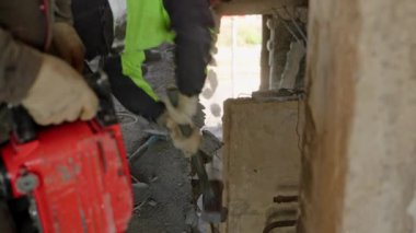 Konut binasındaki molozların hızlı bir şekilde kaldırılması. İnşaat işçileri savaştan zarar görmüş duvarları yıkıyor, yanan dairenin tavanlarını matkapla, balyozla yeniden inşa ediliyor. Yavaş çekim.