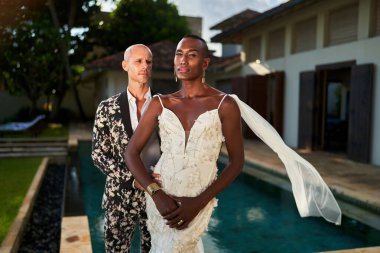 Tropikal villada farklı çiftler evleniyor. Biri kalın takım elbiseli, diğeri zarif beyaz elbiseli. LGBTQ düğün teması, renkli bir tarz. Güzel manzaralı, cinsiyeti değişken eşsiz bir olay..