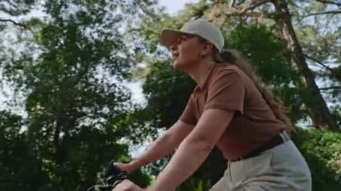 Aktif kadın bisikletçi doğayı keşfeder, bisikletle deniz kenarında macera yaşar. Kadın kozalaklı ormanda bisiklet sürüyor. Deniz manzarasından hoşlanıyor..