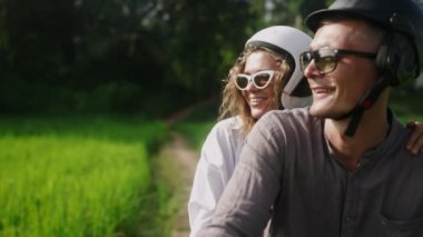 Pirinç tarlasında motosiklette oturan çiftler konuşuyor. Tropiklerde bisiklet süren aşık bir kadın orman plantasyonunu görmek için durmuş. Motosikletle seyahat eden mutlu turistler. Elle gösterilen kız serin görünüm