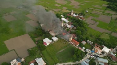 Mestia, Svaneti dağlarındaki yanan Svan kulesinin hava görüntüleri. Tarihsel taş yapısından duman yükseliyor. İtfaiyeciler dağ köyünden cevap veriyor. Acil yangın söndürme mirası..