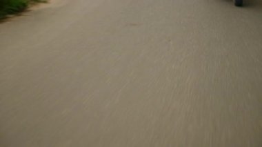 Motosiklet süren bir çiftten diğerine geçiş sahnesi. Mutlu adam ve kadın tropikal yolda motosikletle seyahat ediyorlar. Gezginler palmiye ağaçları boyunca scooter kullanırlar. Turistler gün doğumunda bisiklet yolculuğunun keyfini çıkarırlar..