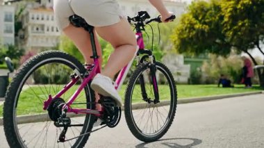Dişi bisikletçi manzarayı, yeşil parkları seviyor. Büyükada Adası caddesinde pembe bisiklet süren bir kadın. Aktif seyahat, bisikletle yeni yerler keşfetmek.