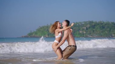 Okyanusta oynayan mutlu evli çift. Kadın adama atlıyor, koca karısını cennet adası yakınlarında denizde döndürüyor. Zayıf erkek arkadaş ve kız arkadaş tatil köyünde romantik tatilin tadını çıkarıyor..