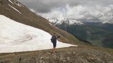 Sırt çantalı hava aracı Svaneti dağlarında yürüyüş yapar. Gezgin karlı tepeleri keşfeder, kollarını açar, büyüleyici manzarayı. Georgia 'daki macera. Dağlarda gezen, temiz hava soluyan, doğayı takdir eden bir adam..