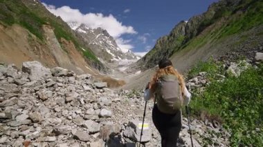 Kadınlar Svaneti dağlarında Chalaadi buzuluna yürüyorlar. Sırt çantalı ve sırıklı bir yürüyüşçü yazın kayalık yolları keşfeder. Karla kaplı tepeleri olan manzaralı dağlık bir arazi. Tek başına sırt çantası macerası. Yavaşla