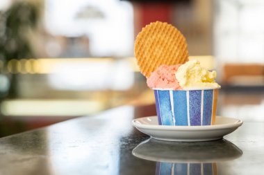 Dondurmacıda iki çeşnili bir küvet dondurma ve bir atölyenin üstünde kurabiye.