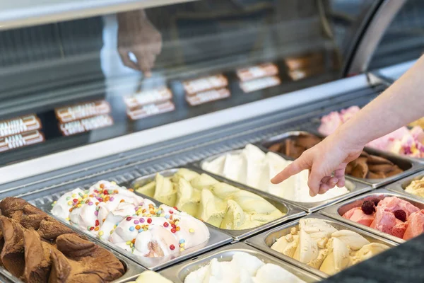 stock image Close-up of a Scene with somebody choosing a flavor of ice cream in a store with a female assistant