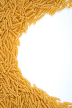 Beyaz zemin üzerine istiflenmiş sarı, kuru makarna eriştelerinin üst görünümü sağ arka planda fotokopi alanı olan homojen bir doku yaratıyor.