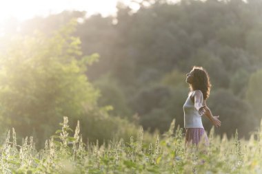 Huzurlu bir çayırda meditasyon yapan genç bir kadınla manzara