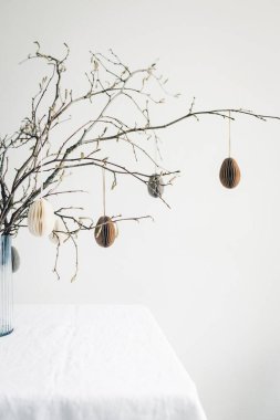 Easter paper eggs hanging on branches. Easter tablescape decor.