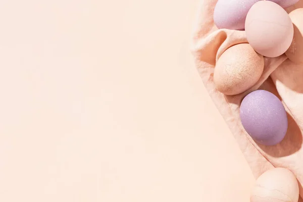 复活节背景 色彩艳丽的彩蛋在亚麻布餐巾上 带有复制空间的简约风格的流行复活节贺卡 图库图片