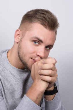 Bileğine saat takmış genç sarışın bir adam zamanı kontrol ediyor..