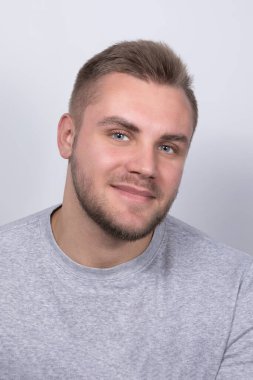 Gri gömlekli, sakallı, gülümseyen sarışın bir adam.