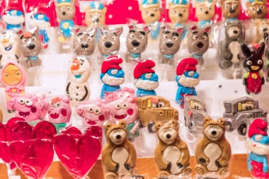 Varşova, Polonya - 6 Ocak 2023.Parlak ve renkli lolipoplar, popüler çizgi film karakterlerini andırıyor. Masaya güzelce yerleştirilmiş, bir partide çocuklara neşe getirmeye hazır..