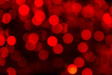 Çok sayıda yumuşak kırmızı Bokeh ışıklarının olduğu canlı bir arka plan sıcak ve davetkar bir atmosfer yaratır. Dairesel şekiller, sanatsal ve şenlikli temalar için idealdir..