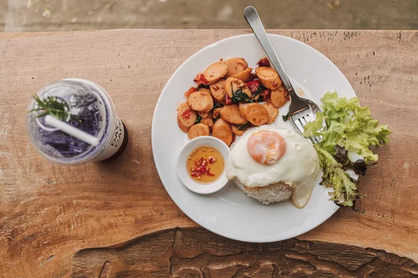 Kızarmış sosisli Tayland pilavı ve sahanda yumurtalı fesleğen..